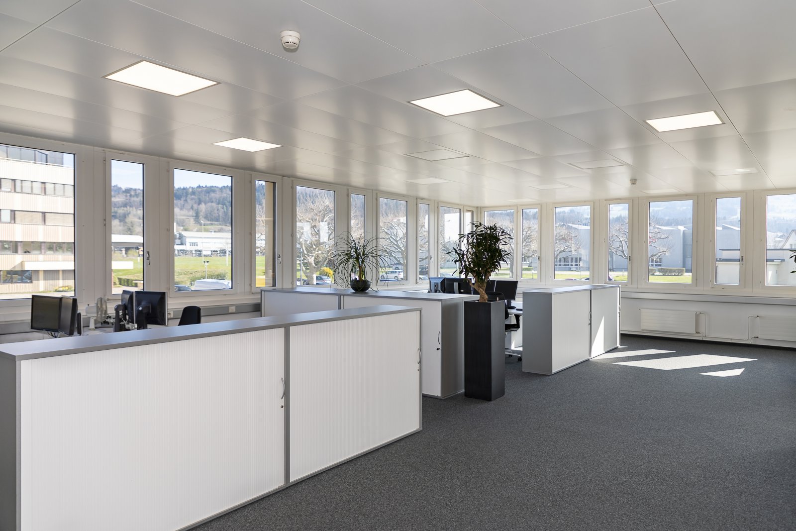 Lichtdurchflutetes Büro mit Panoramaverglasung und flexiblen Arbeitsplätzen