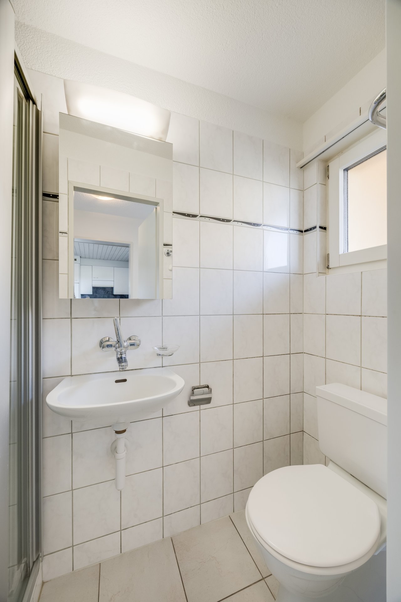 Praktisches Badezimmer mit Dusche, Waschtisch und Spiegelschrank